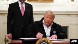 رئیس جمهور ترمپ در حال امضای لایحه‌ای اضطراری برای مبارزه با ویروس کرونا