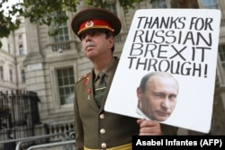 Брекзитке каршы чыккан британдык жаран Стив Брэй орус аскер кийимин кийип, Путиндин сүрөтүн көтөрүп, нааразылык акциясын өткөрдү. Лондон. 2020-жылдын 1-сентябры.