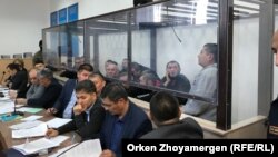 Сот залында. «Террордук уюмга тиешеси бар» деп айыпталгандар ок өтпөй турган айнектин ары жагында. Нур-Султан шаары. 22-октябрь, 2019-жыл.