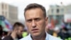 A person watches a video on social media showing Russian opposition leader Aleksei Navalny being carried on a stretcher by an ambulance team in Omsk on August 20.