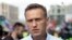 A person watches a video on social media showing Russian opposition leader Aleksei Navalny being carried on a stretcher by an ambulance team in Omsk on August 20.