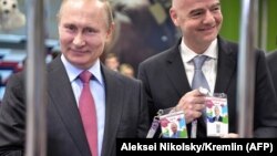 Президент Росії Володимир Путін (л) та президент ФІФА Джанні Інфантіно позують із ідентифікаційними картками вболівальника чемпіонату світу з футболу, Сочі, 3 травня 2018 року