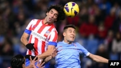 Надпись «Азербайджан» на футболке игрока  Атлетико Мадрид Арда Турана (слева). Момент  игры на стадионе Висенте Кальдерон в Мадриде во время матча Испанской лиги. 2012