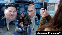  Фигуры президентов Северной Кореи и России, Ким Чен Ына и Владимира Путина, в виде акул на карнавале в Португалии