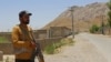 A security guard stands along a street near the site of an explosion that hit a school bus in the Khuzdar district of Balochistan Province on May 21. 