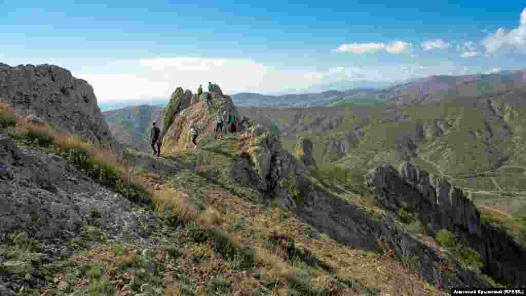 Хребет Хашкі-Кая &ndash; це відокремлений від інших фрагмент Головної гряди Кримських гір у південно-східній частині півострова. &nbsp; На цьому фото туристи піднімаються на Хашкі-Кая з боку дороги в село Ворон