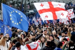 Грузини з прапорами ЄС та національними стягами святкують надання Грузії статусу кандидата в ЄС на вулиці Руставелі в Тбілісі, 15 грудня 2023 року