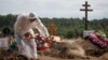 A grave digger wearing personal protective equipment as a preventive measure against COVID-19 buries a person at a graveyard on the outskirts of St. Petersburg on June 25.