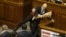 Ukraine -- Parliament deputy Oleh Barna tries to remove Prime Minister Arseniy Yatsenyuk from the tribune, after presenting him a bouquet of roses, during a parliament session in Kyiv, December 11, 2015