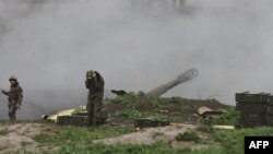 Nagorno-Karabakh -- Armenian servicemen of the self-defense army of Nagorno-Karabakh fire an artillery shell towards Azeri forces from their positions in the town of Martakert , April 3, 2016
