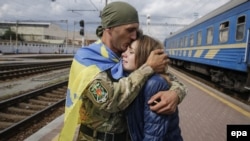 Український військовослужбовець обіймає свою дівчину після повернення з фронту. Київ, вересень 2015 року