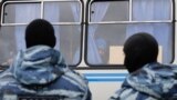 Russia - Migrant worker looks out of a police vehicle, OMON