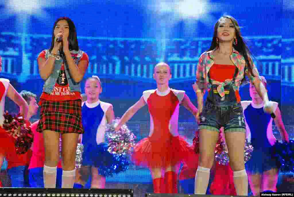 По стопам матери В семье Дариги Назарбаевой дети пошли по стопам родителей. Старший сын Айсултан, как и его отец Рахат Алиев, экс-заместитель председателя КНБ, ныне скрывающийся от казахстанской Фемиды в Европе, тоже имеет отношение к спецслужбам (по официальной информации он числится в штате военной контрразведки). Дочь же Венера теперь поет на сцене. Ее дебют как певицы состоялся на одном из предыдущих ретрофестивалей. Спела она и на 14-м. Вместе с Сарой Амангельды и Маликой Есмухамедовой она исполнила песню &laquo;Baby One More Time&raquo; из репертуара американской певицы Бритни Спирс. На фото: Венера Назарбаева на сцене (слева с микрофоном в руке).