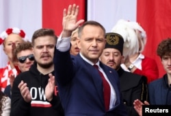 Караль Наўроцкі вітае прыхільнікаў на маршы ў Варшаве