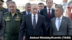 Öň hatarda: Russiýanyň Goranmak ministri Sergeý Şoýgu, Russiýanyň prezidenti Wladimir Putin hem Tatarstanyň prezidenti Rustam Minnihanow Kazan şäherindäki “Tupolew” önümçilik birleşiginiň bölümi bolan S.P. Gorbunow adyndaky awiasiýa zawodyna sapar edýärler. 2019-njy ýylyň maýy.