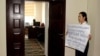 Анара Мамбеталиева в здании Госэкотехинспекции вышла на акцию с плакатом в руках.