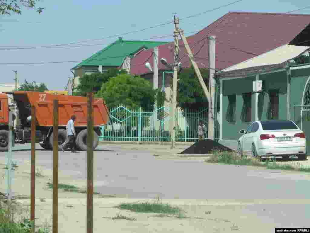 Şor obasy. Adamlar käte özleri asfalt satyn alyp, jaýlarynyň ýanyna düşeýärler.