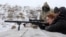 Женщина целится из оружия во время военных учений для работников основных городских предприятий и служб. Украина, 25 января 2022 года